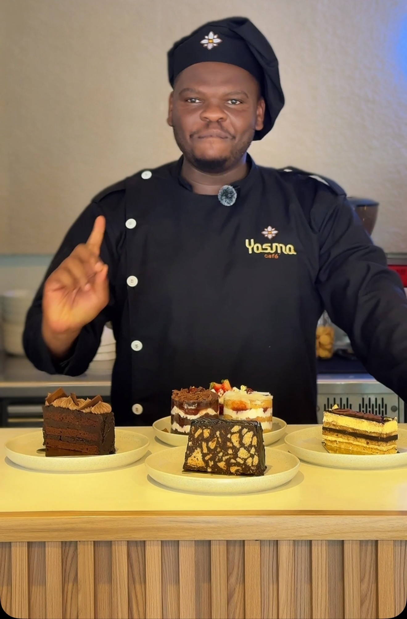 Yasma's chef in uniform presenting the day's cakes