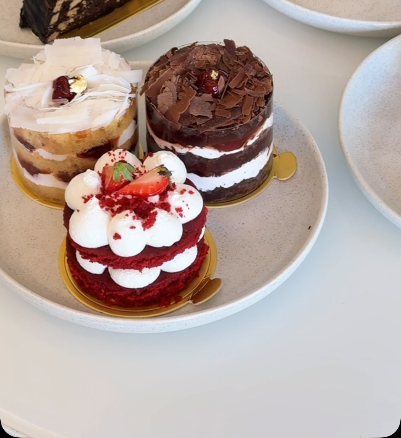 Mini cakes and desserts on speckled plates at Yasma
